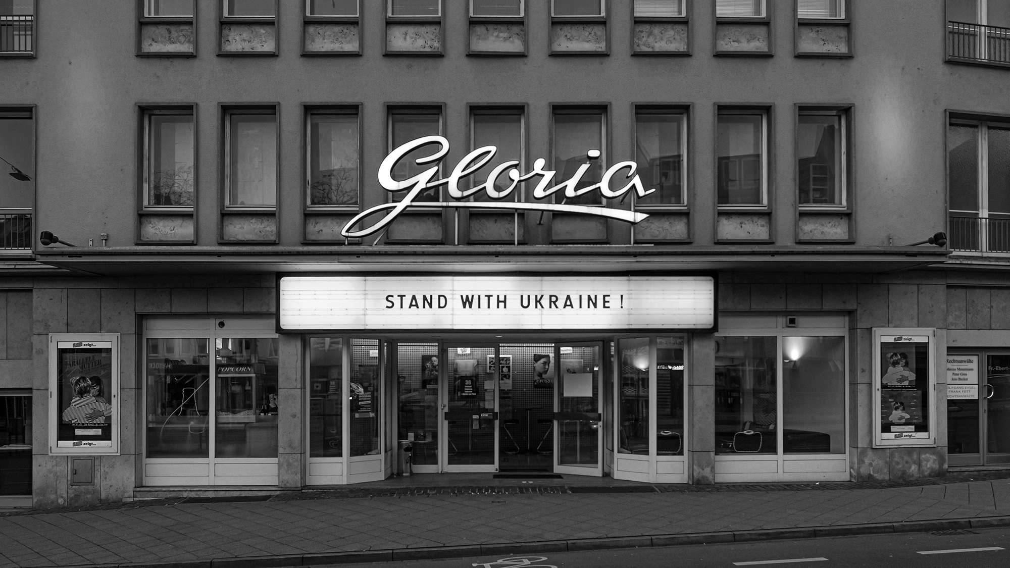 Leuchtreklame über einem Kino mit Solidaritätsbekundung mit der Ukraine - Stand with Ukraine!